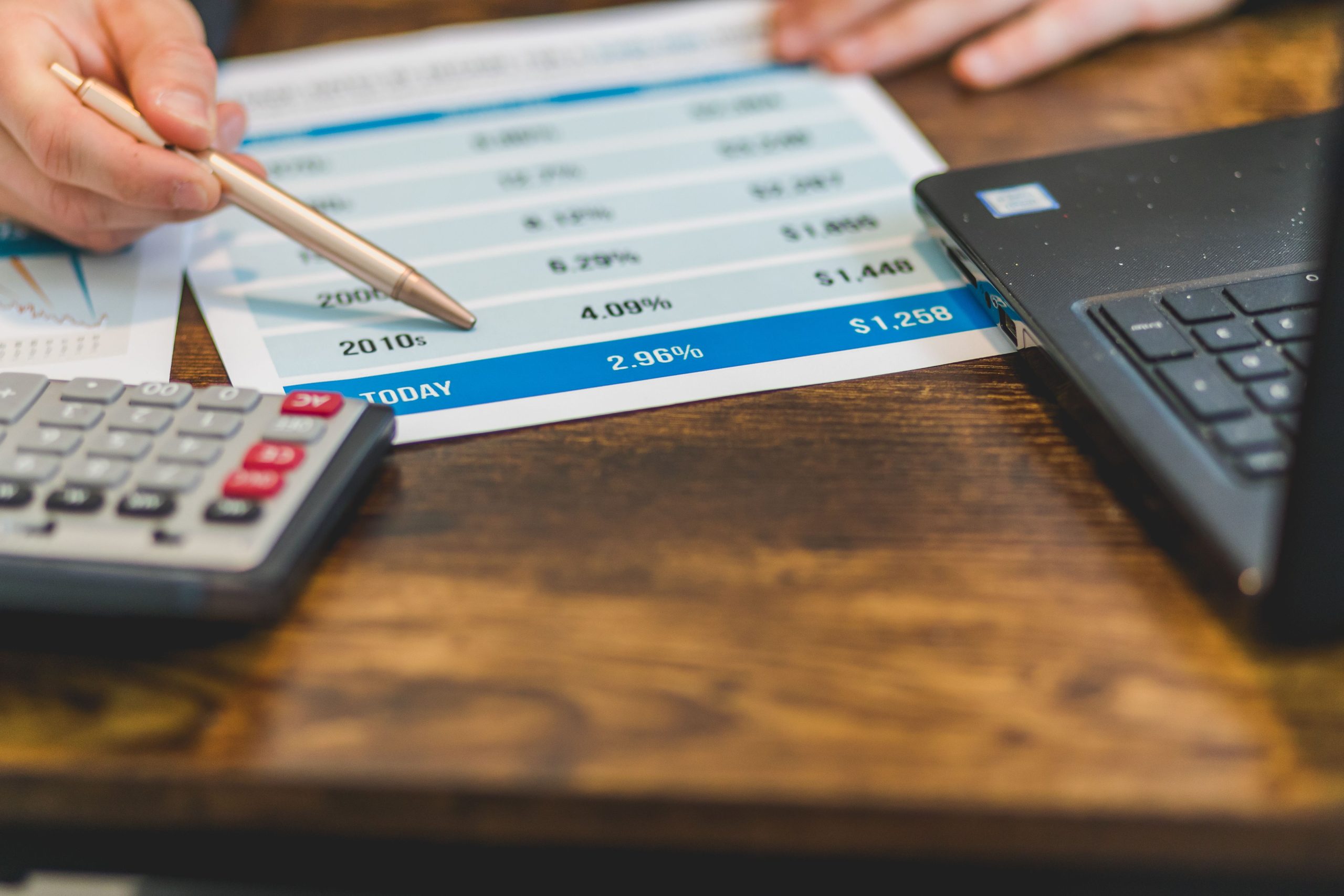 Main avec stylo analysant taux financiers et calcul