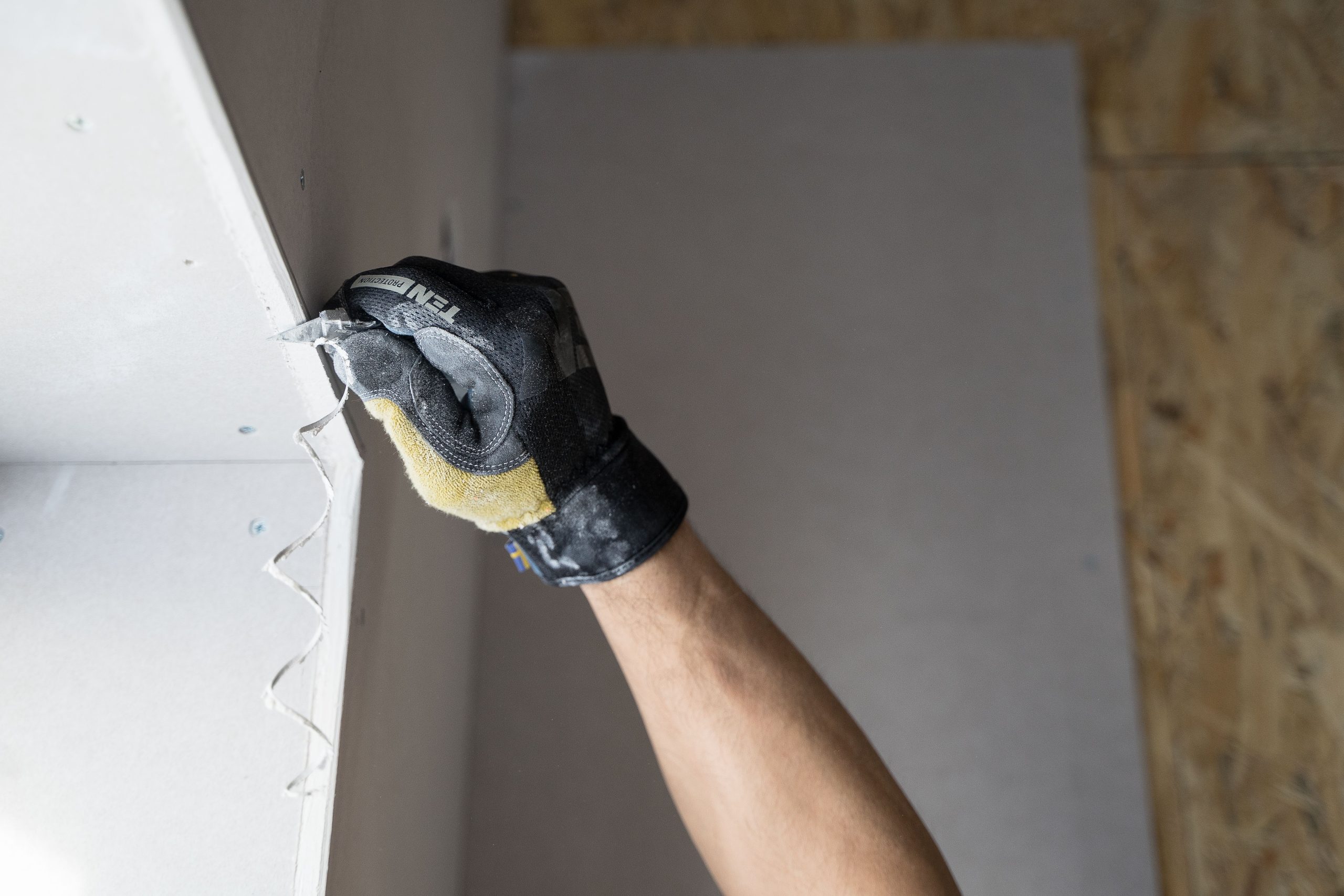 Main gantée appliquant enduit mur intérieur