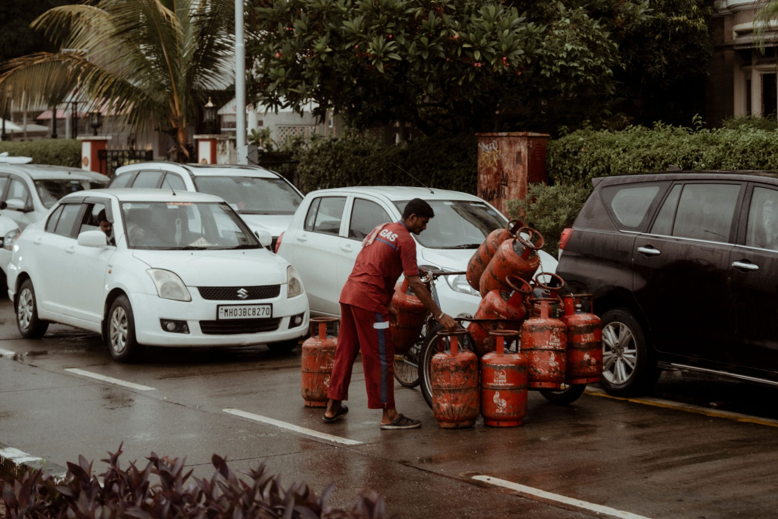 Livreur transportant des bouteilles de gaz sous la pluie