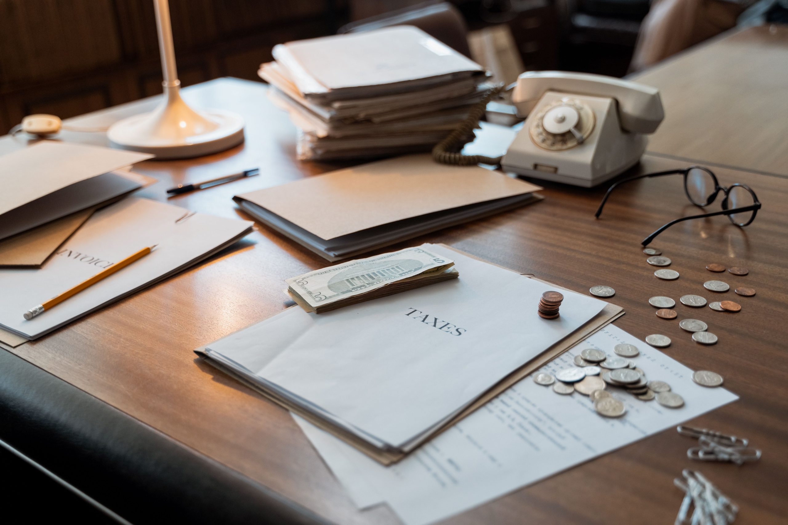 Bureau avec documents fiscaux, pièces et lunettes pour la gestion financière
