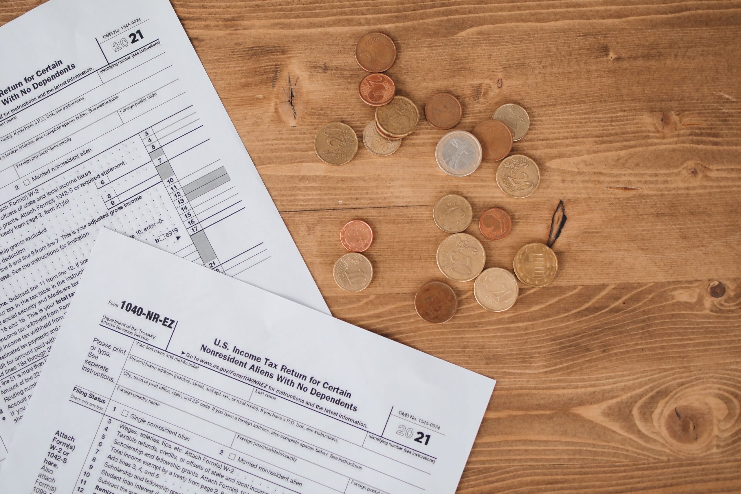 Formulaires d'impôts et pièces de monnaie sur table en bois