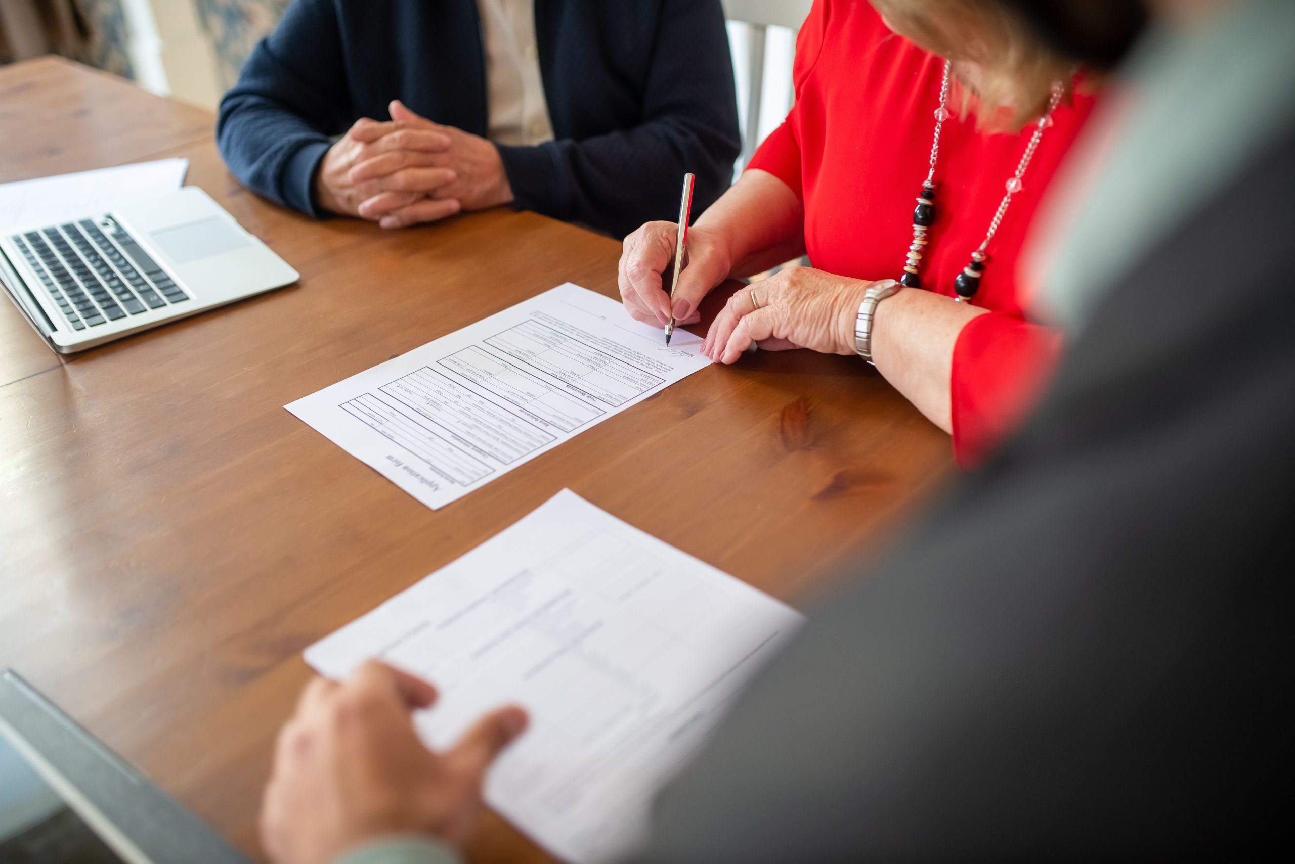 Deux adultes signent des documents autour d'une table