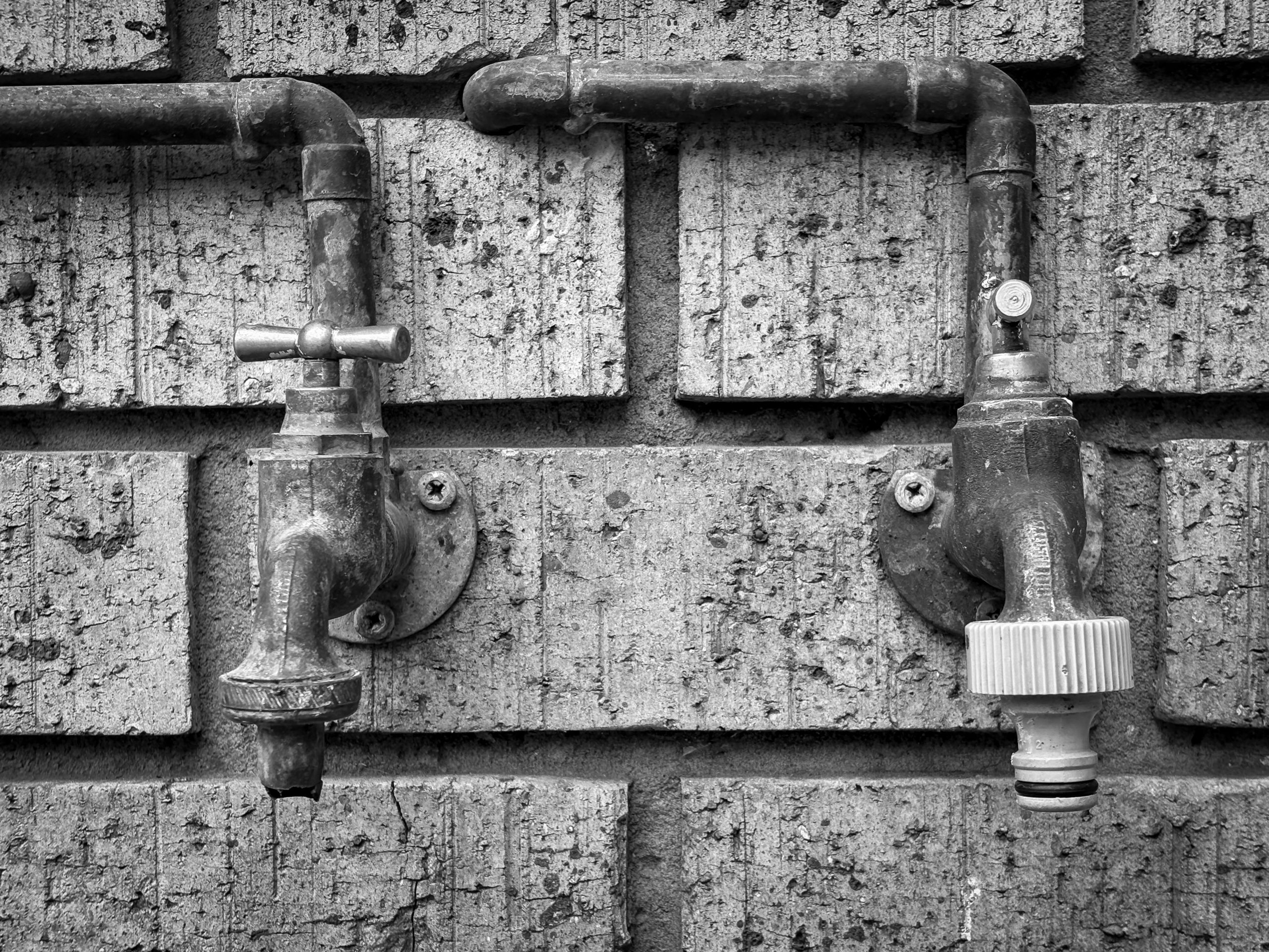 Anciens robinets extérieurs sur mur brique