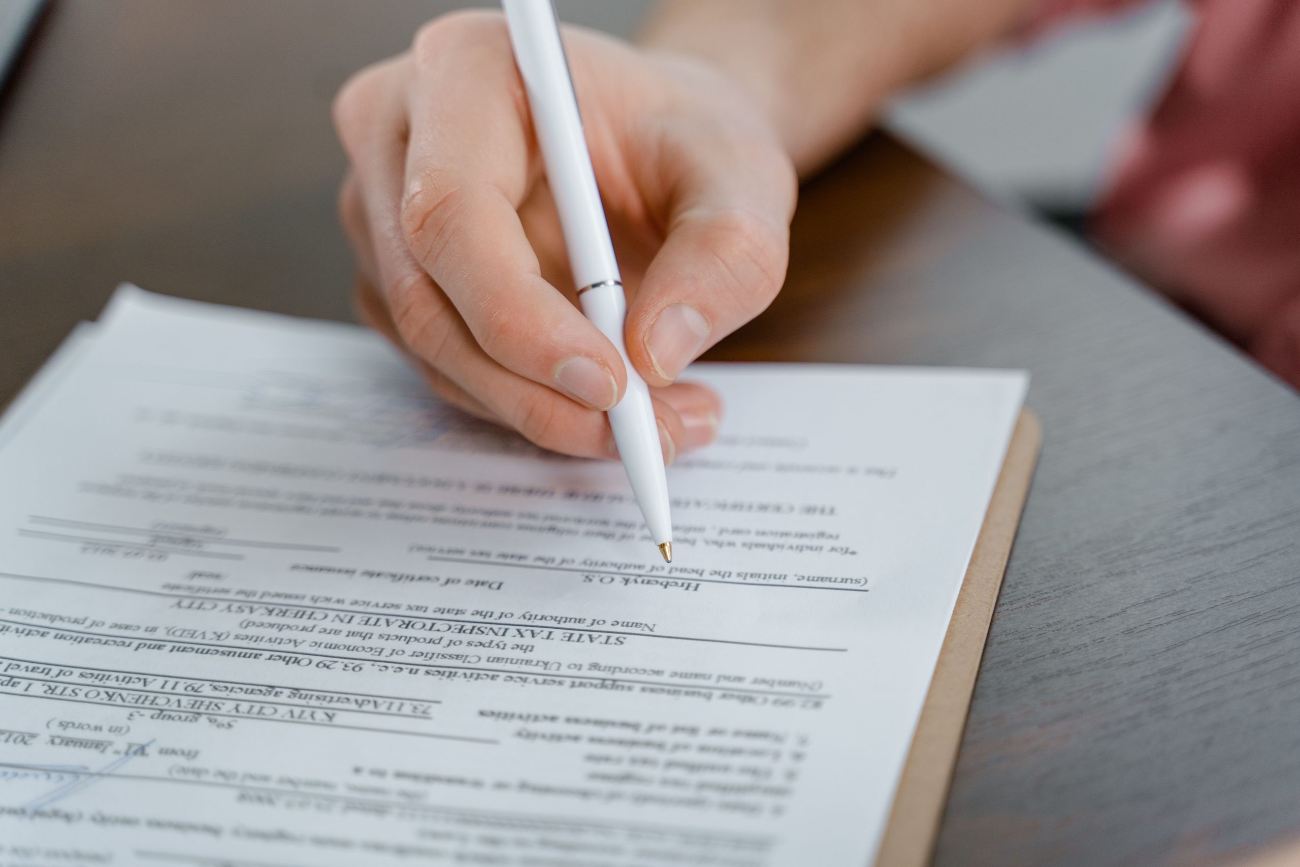 Main tenant un stylo signant un document
